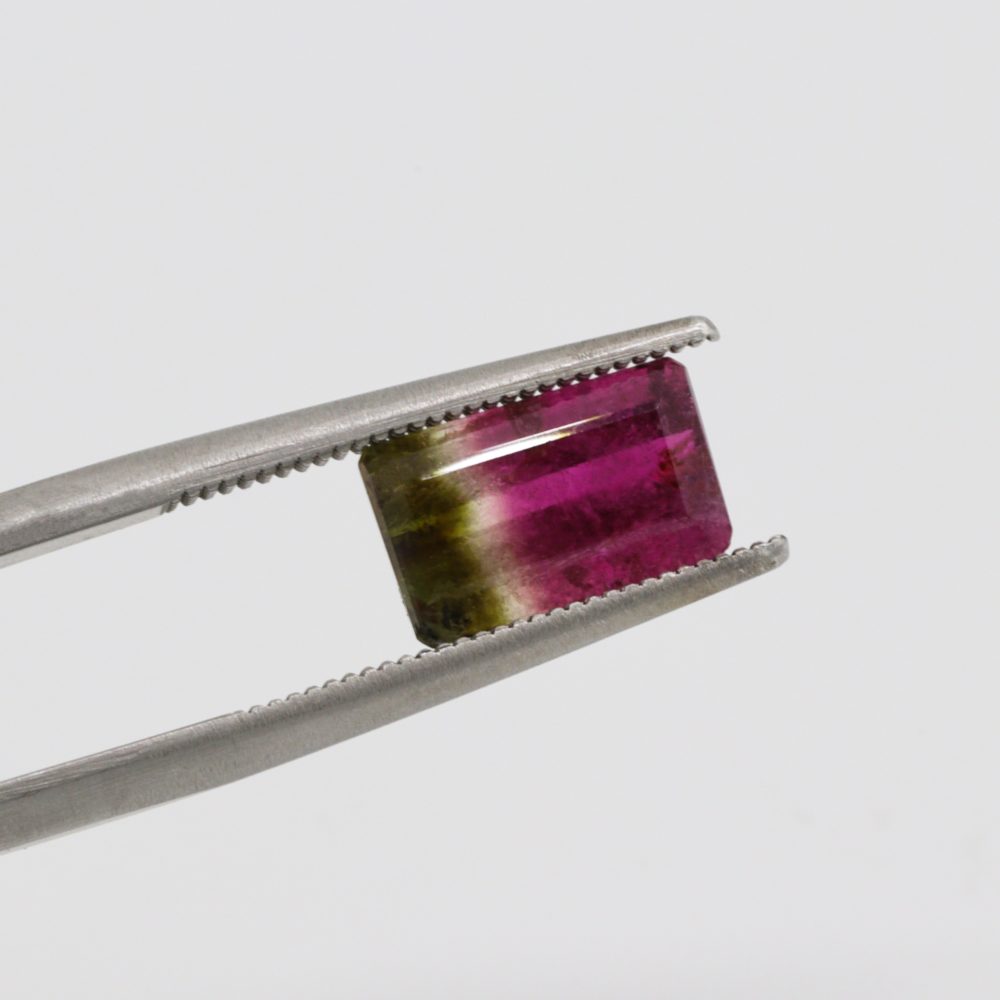 Image of a gem being evaluated, held in tweezers.