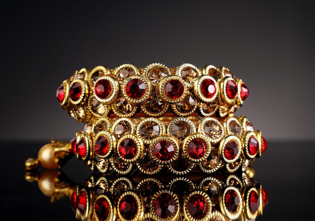 Image of gold and ruby bracelets stacked on top of eachother.