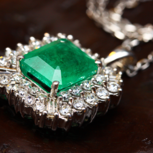 Close-up image of an emerald and diamond necklace. We buy precious gemstones.
